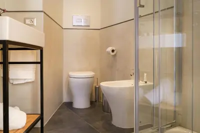 a bathroom with a toilet and a glass shower at The Cross Hotel in Rome
