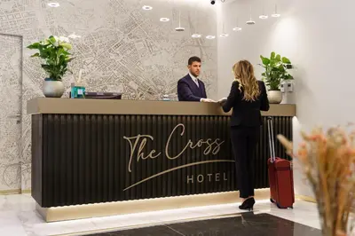 a man and a woman standing at a hotel counter at The Cross Hotel in Rome