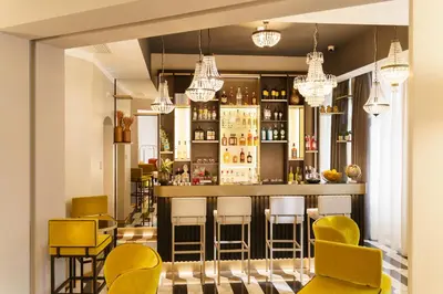 a bar in a restaurant with yellow bar stools at The Cross Hotel in Rome