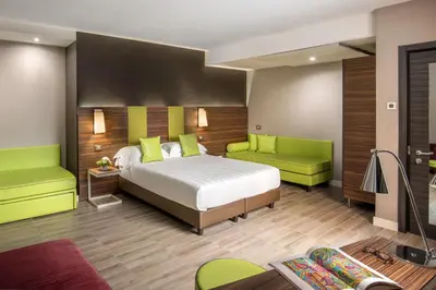 a bedroom with a bed and two green chairs at The Republic in Rome