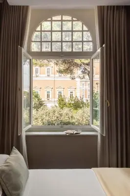 a bedroom with a window with a view of a building at Hotel Viminale in Rome