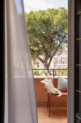 a balcony with a table and a chair and a window at Hotel Viminale in Rome