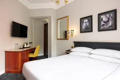 a hotel room with a bed and a desk and a television at Hotel Barberini in Rome