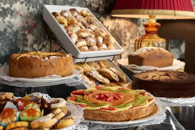 a table with different types of cakes and pastries at Hotel Barberini in Rome
