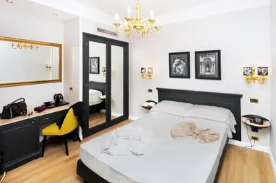 a bedroom with a bed and a desk and a mirror at Hotel Barberini in Rome