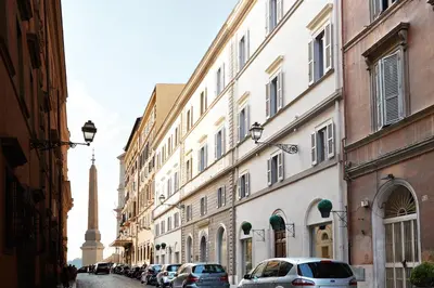 a street with buildings and cars parked on the street at The Code Hotel in Rome