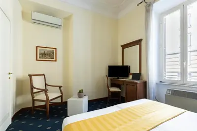 a bedroom with a bed and a desk and a television at Hotel Coppede' in Rome
