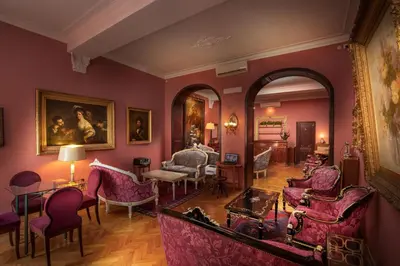 a living room with pink walls and chairs at Residenza Frattina in Rome