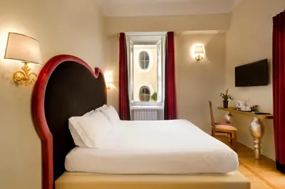 a bedroom with a white bed and a window at Residenza Frattina in Rome