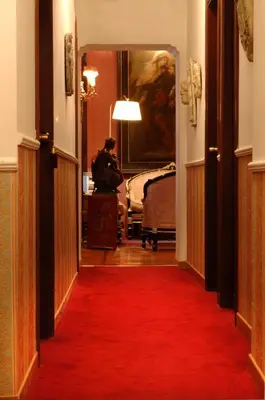 a hallway with a red carpet and a room with a bed at Residenza Frattina in Rome