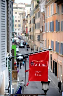a red flag hanging from a building on a city street at Residenza Frattina in Rome