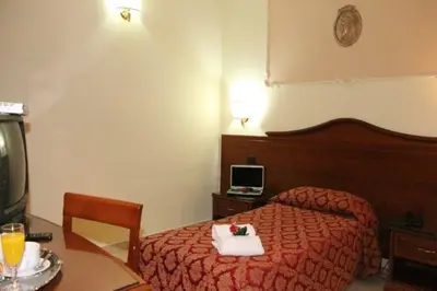 a hotel room with a bed and a table with a plate of food at Hotel Mirage in Rome