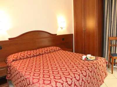 a bedroom with a bed with a red comforter at Hotel Mirage in Rome