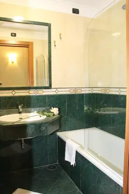 a bathroom with a sink and a tub and a mirror at Hotel Mirage in Rome