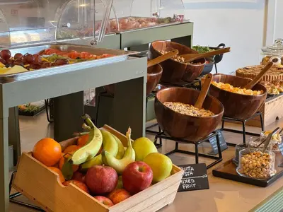 a buffet with bowls of vegetables and other food at La Griffe Hotel Roma in Rome
