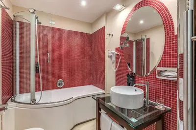 a bathroom with a shower with red tiles at La Griffe Hotel Roma in Rome