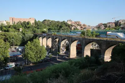 a train is crossing a bridge over a city at B&B All'Ombra di San Pietro in Rome