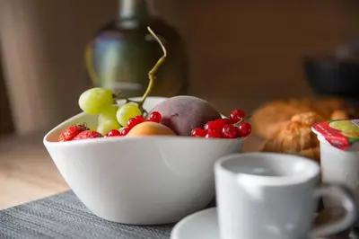 a bowl of fruit on a table with a cup of coffee at B&B All'Ombra di San Pietro in Rome
