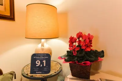 a table with a lamp and a clock and flowers at B&B All'Ombra di San Pietro in Rome