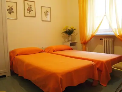 two beds in a room with orange sheets at B&B All'Ombra di San Pietro in Rome