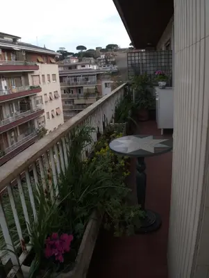 a balcony with a table and some plants and buildings at B&B All'Ombra di San Pietro in Rome