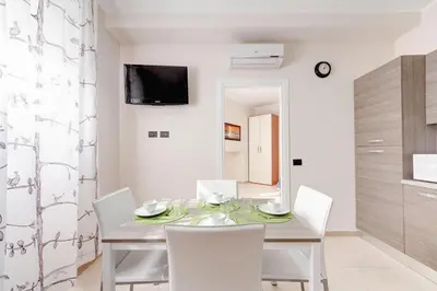 a dining room with a table and white chairs at Olimpo Apartments St John in Lateran in Rome