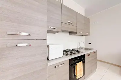 a kitchen with wooden cabinets and a stove top oven at Olimpo Apartments St John in Lateran in Rome