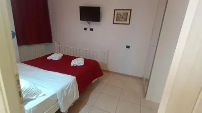 a small bedroom with a bed and a tv at Olimpo Apartments St John in Lateran in Rome