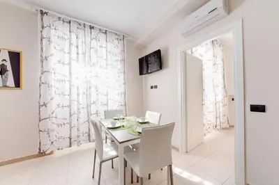 a white dining room with a white table and white chairs at Olimpo Apartments St John in Lateran in Rome