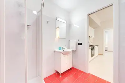 a white bathroom with a sink and a shower at Olimpo Apartments St John in Lateran in Rome