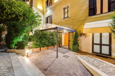 an entrance to a building with an umbrella at Romoli Hotel in Rome
