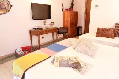 a bedroom with two beds with a tv and a newspaper at Hotel Sant'Angelo in Rome