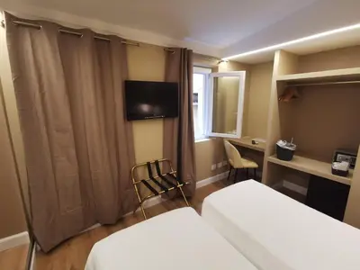 a room with a black chair and two tables at Hotel Fiori in Rome