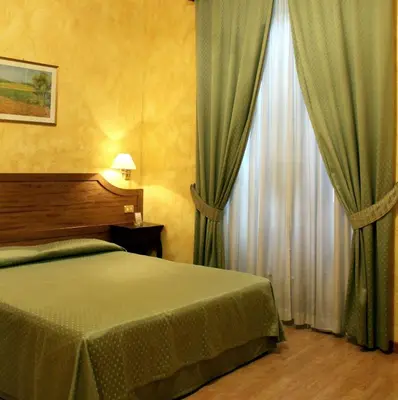 a dining room with tables and chairs against a wall at Hotel Fiori in Rome
