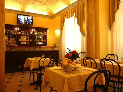 a dining room with tables and chairs and a bar at Cambridge Hotel in Rome