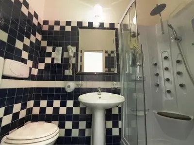 a bathroom with a sink and a toilet and a shower at Cambridge Hotel in Rome