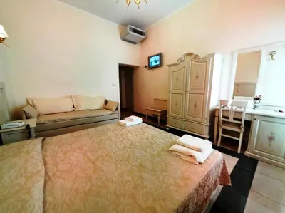 a bedroom with a large bed and a couch at Cambridge Hotel in Rome