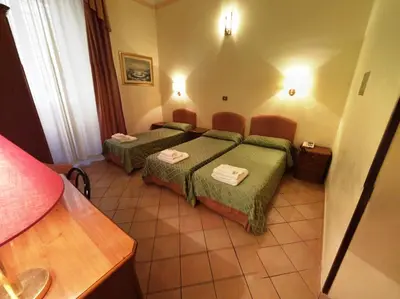 a hotel room with two beds in a room at Cambridge Hotel in Rome