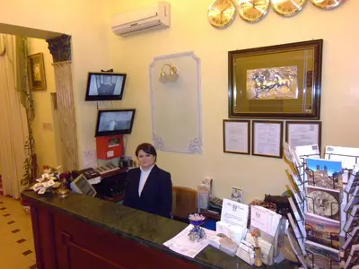 a woman sitting at a desk in a office at Cambridge Hotel in Rome