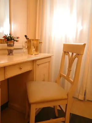 a chair sitting next to a desk with a bottle of wine at Cambridge Hotel in Rome