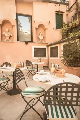 a patio with tables and chairs in front of a building at Hotel Donatello in Rome