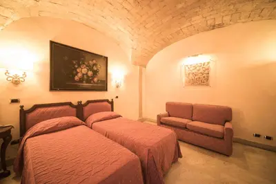 a bedroom with two beds and a couch at Hotel Donatello in Rome