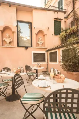 a patio with tables and chairs and a building at Hotel Donatello in Rome