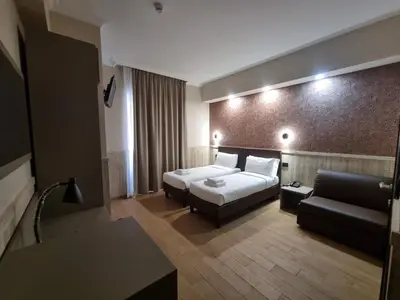 a hotel room with a bed and a couch at Hotel Pyramid in Rome