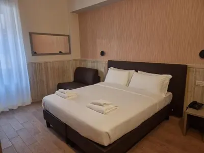 a bedroom with a large bed and a chair at Hotel Pyramid in Rome
