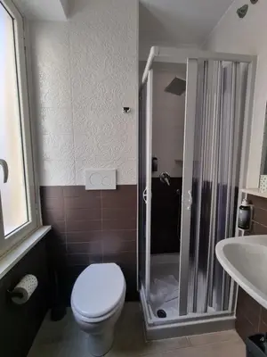 a bathroom with a shower and a toilet and a sink at Hotel Pyramid in Rome