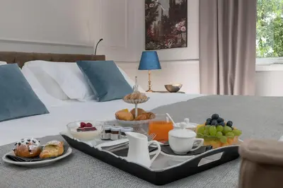 a tray of breakfast foods on a bed at Hotel La Ville Rome in Rome