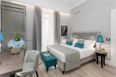 a bedroom with a bed and a table and chairs at Hotel La Ville Rome in Rome