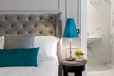 a bed with a blue lamp on a side table at Hotel La Ville Rome in Rome