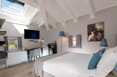 a bedroom with a bed and a desk and a tv at Hotel La Ville Rome in Rome